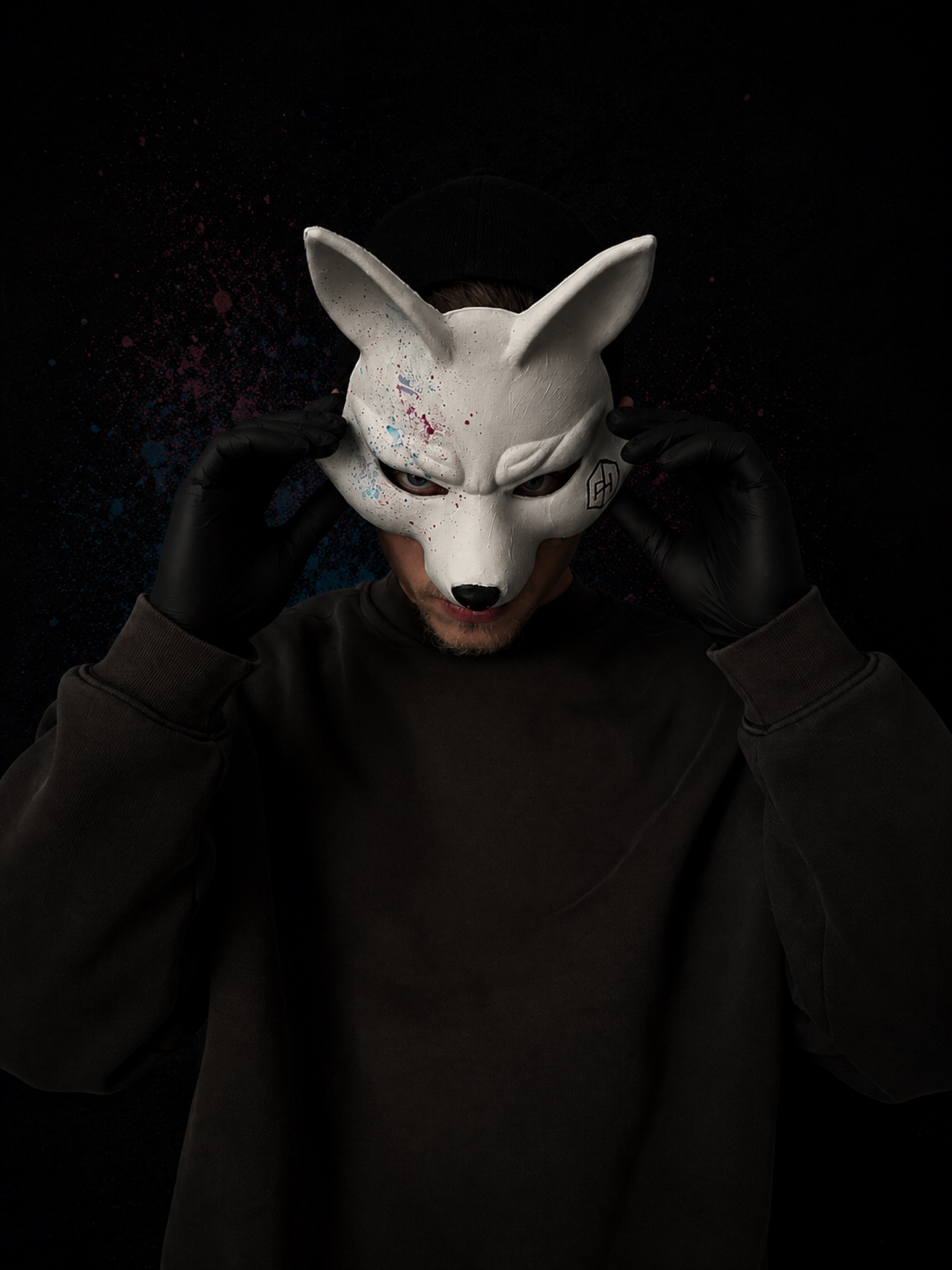 PHantm wearing a white fox mask and holding a painting